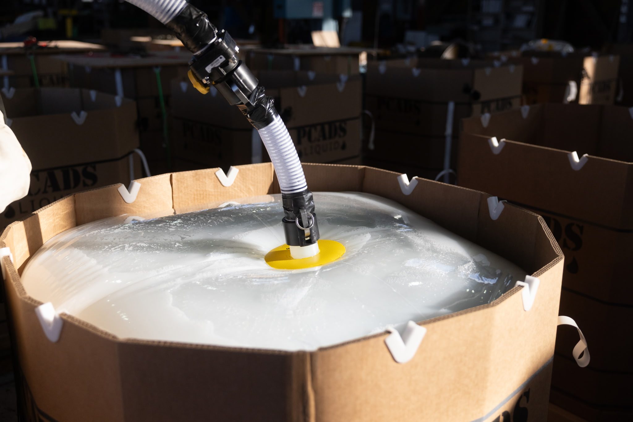 Fire retardant being pumped through a yellow fill port into a PCADS Liquid container