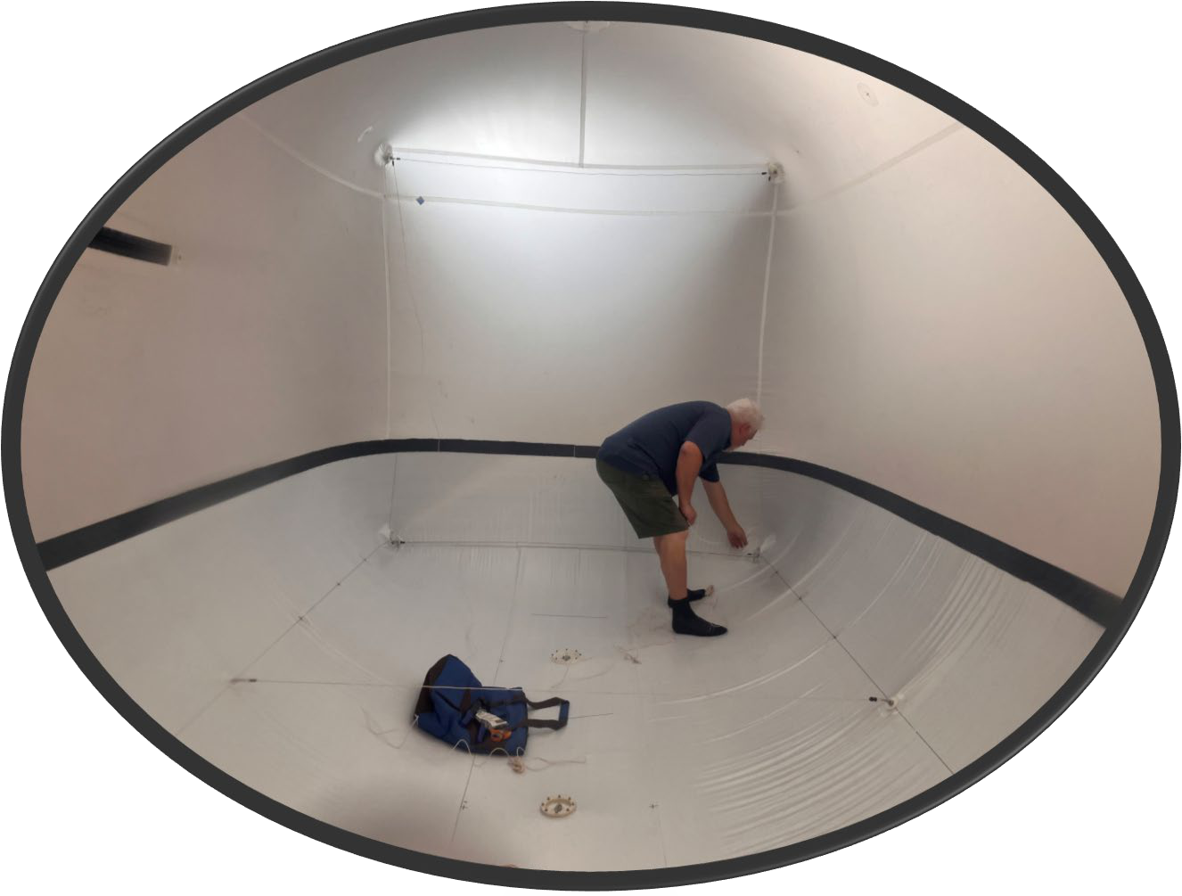 Technician inspecting the internal tension structure inside a lighting balloon in the fabrication shop