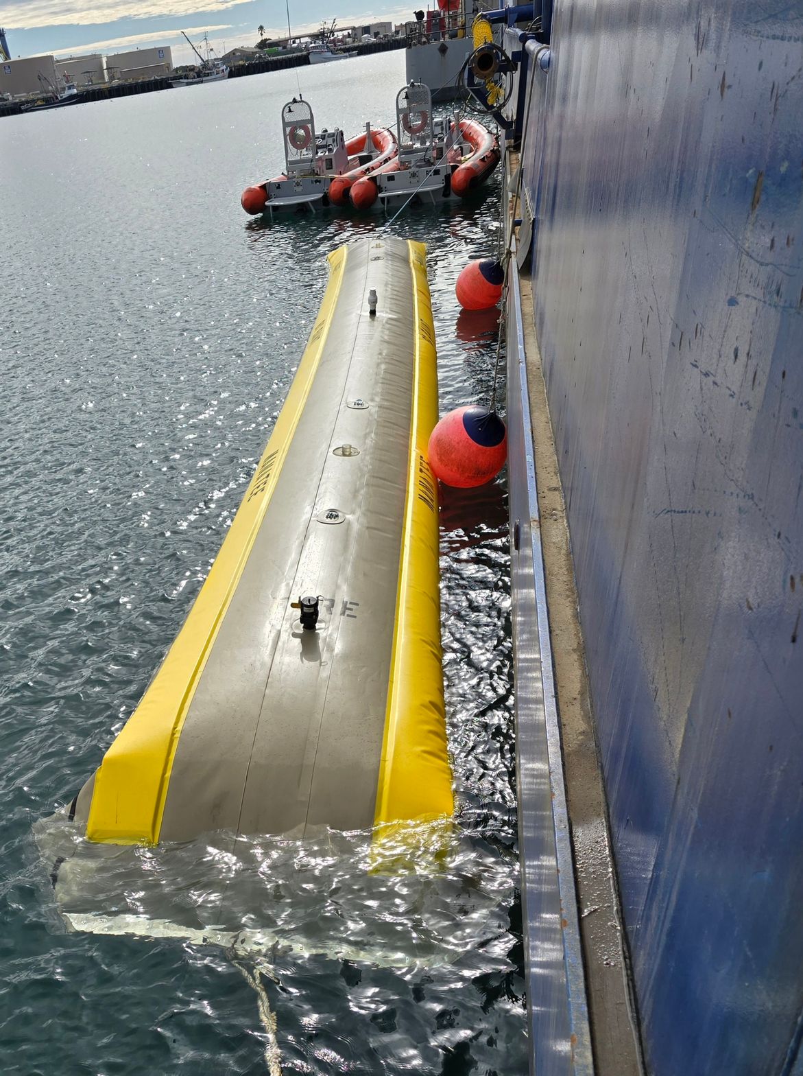 Manatee tow tube filled with seawater alongside a vessel hull