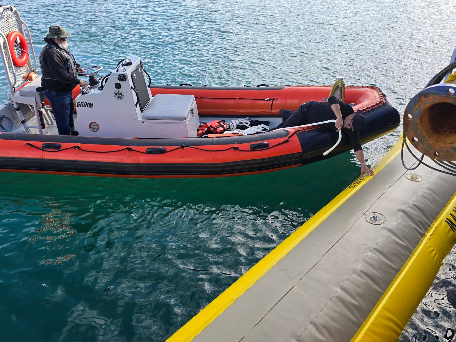 Crew rigging the tow line to the Manatee from a rigid-hull inflatable boat