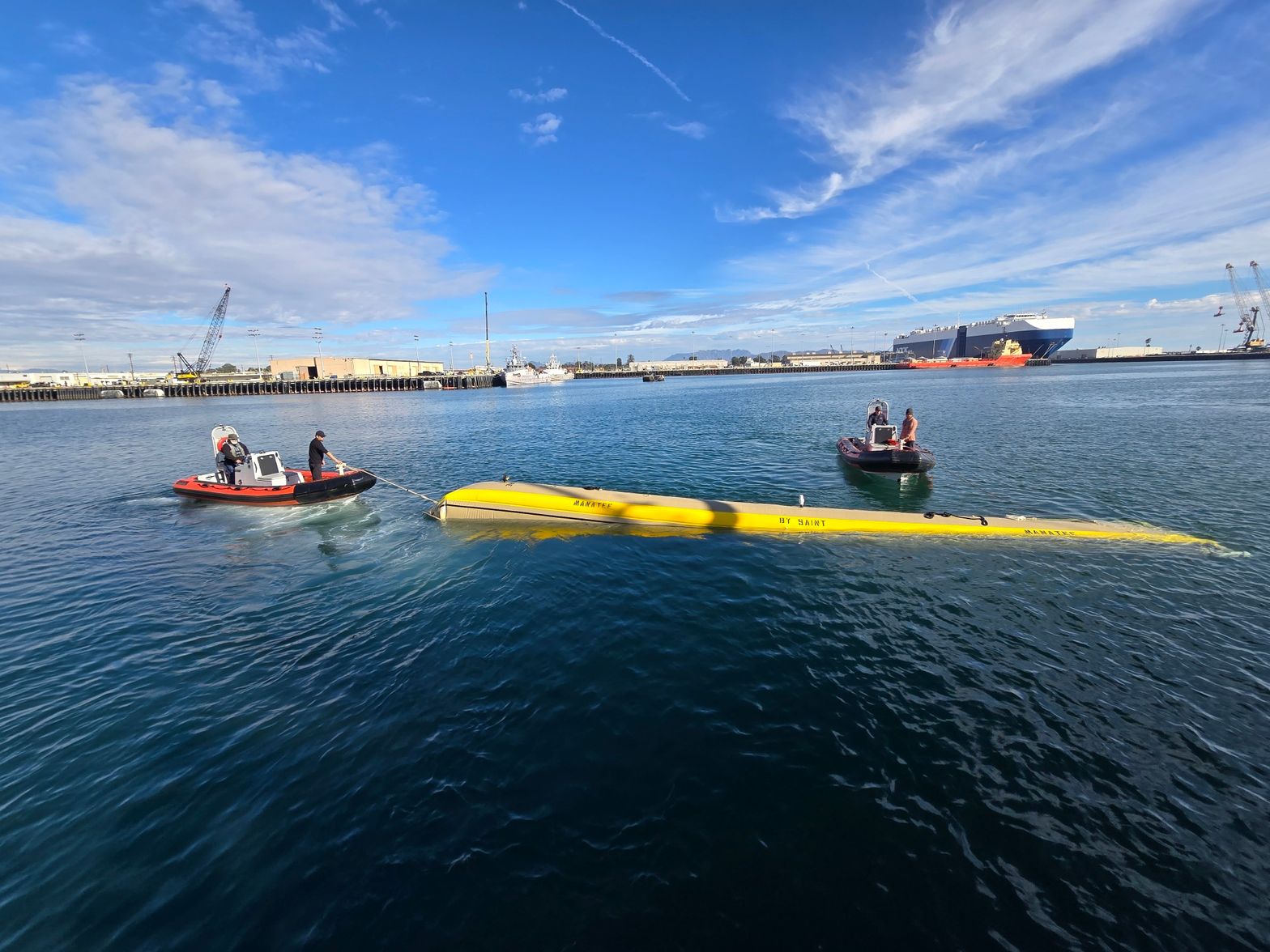 Manatee tow tube under tow in the harbor with two support craft