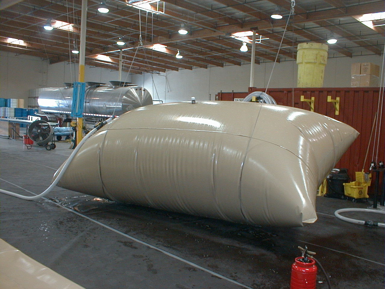 Custom coated-fabric vessel tank filled to capacity on the shop floor during pressure testing